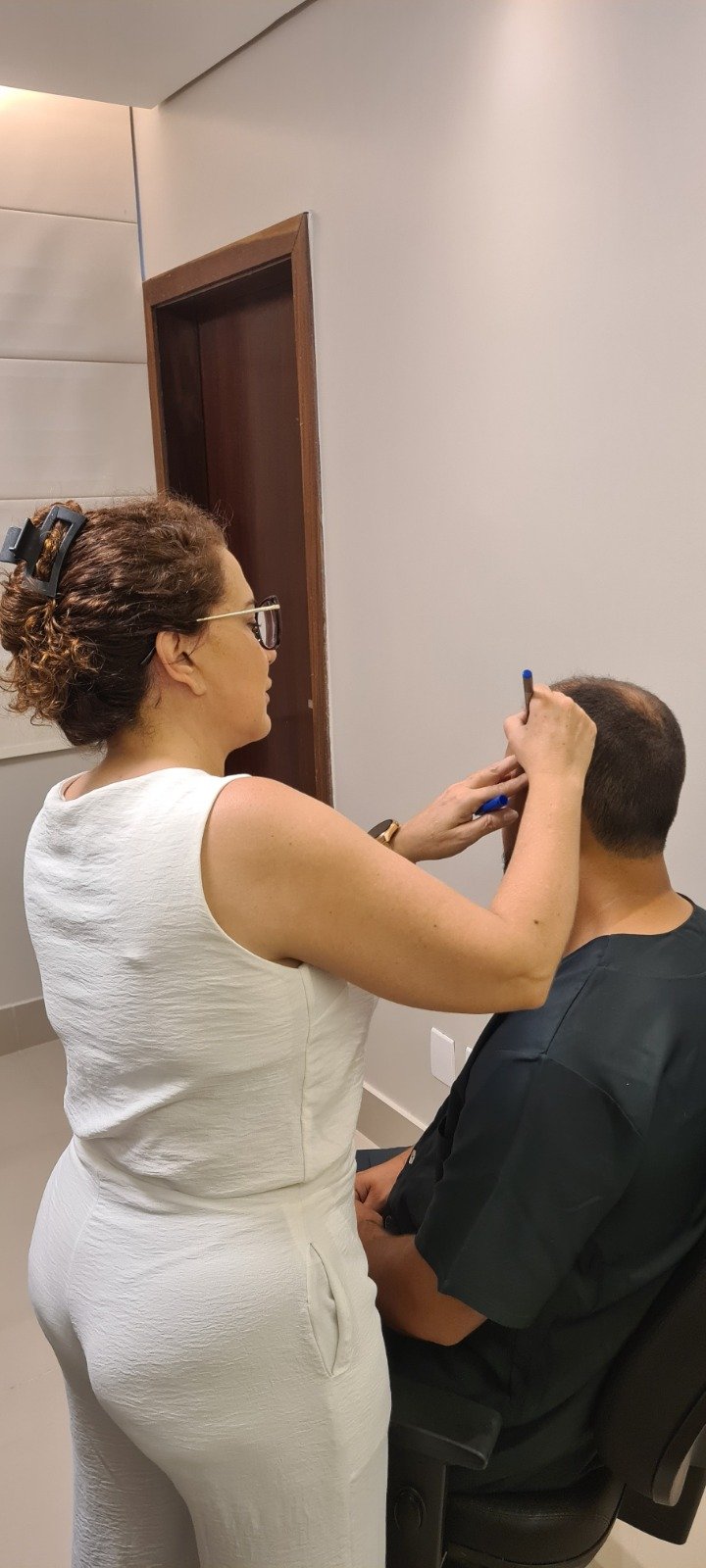 Dra. Andrea Viana de Matos marcando a linha capilar antes do transplante capilar FUE